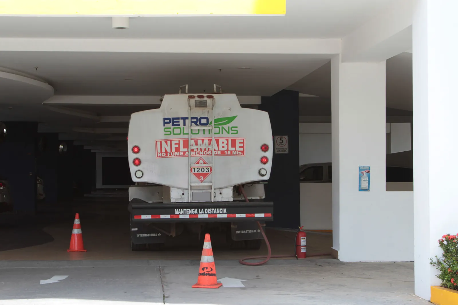 Camión cisterna de PetroSolutions entregando combustible en el estacionamiento de un edificio